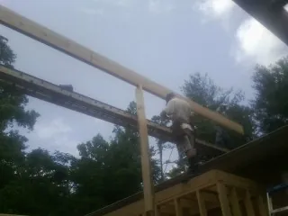 Carpenter setting a ridge beam over a new addition frame — Ice Dam Removal by Roofing Brothers in Westbrookville