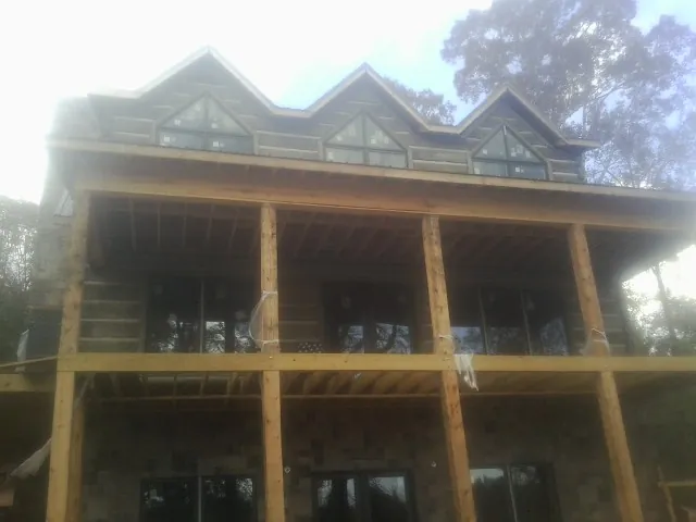 Dormers and porch framing on a large log home under construction — Roof Coating work by our crew in Westbrookville